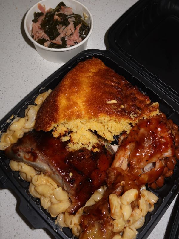 Plate of BBQ ribs, chicken, mac and cheese, and cornbread